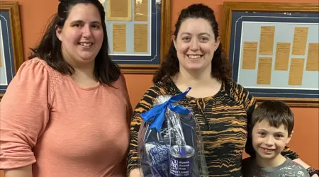 AAACU Team member presents a check to a member of the Cheboygan High School Senior Class of 2025